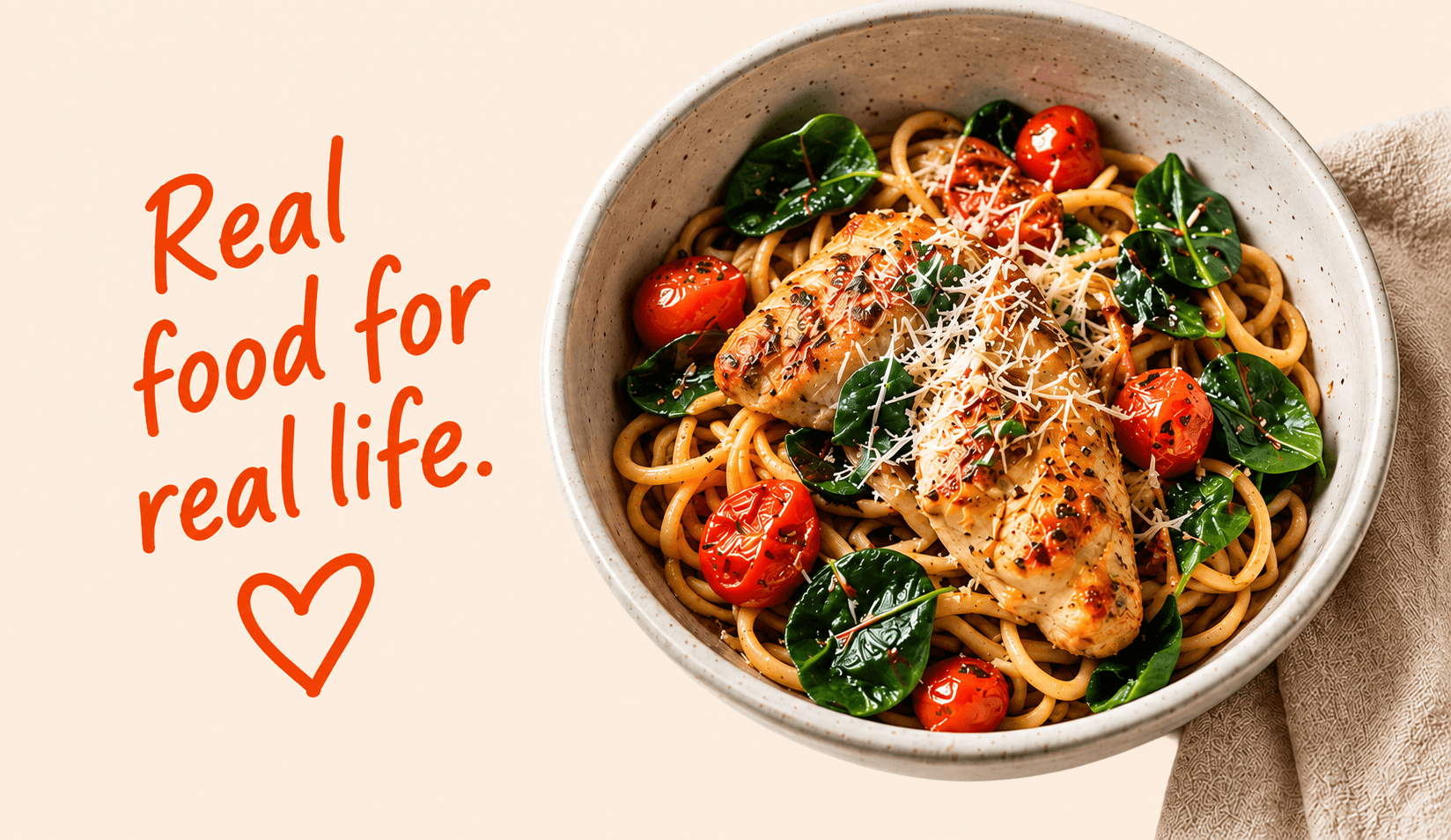 A bowl of chicken pasta with spinach and cherry tomatoes. Real food for real life.